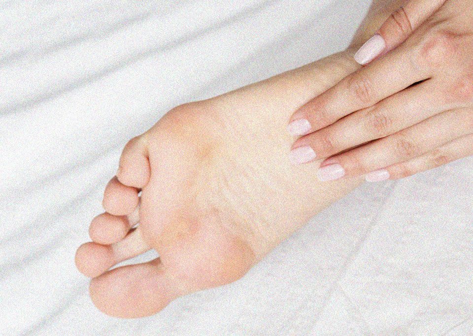 planta dos pés sendo massageada por uma das mãos